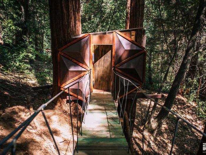 A small bridge connects the main house to a ground-level bathroom.