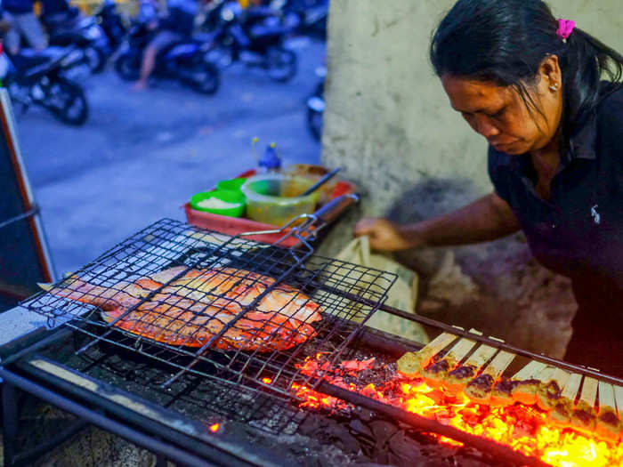 His wife cooks the fish in a metal barbecue cage over a charcoal grill with traditional Indonesian spices, including ground shallot, garlic, chili pepper, coriander, tamarind juice, candlenut, turmeric, galangal, and salt.