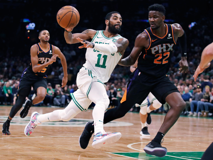 Boston Celtics point guard Kyrie Irving glides past rookie DeAndre Ayton.