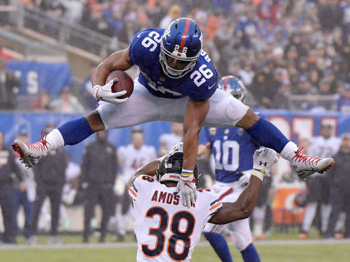 New York Giants rookie Saquon Barkley hurdles his defender.