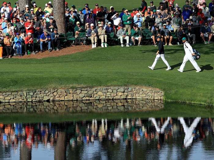 Jordan Spieth and caddie Michael Greller walk in step to the 15th green at the Masters.