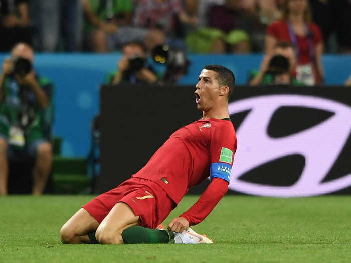 Cristiano Ronaldo slides towards the crowd after completing his hat trick to steal a draw against Spain.