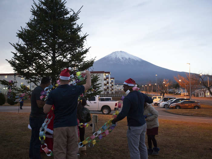 Mount Fuji rises in the background as US Marines decorate a Christmas tree in Japan.