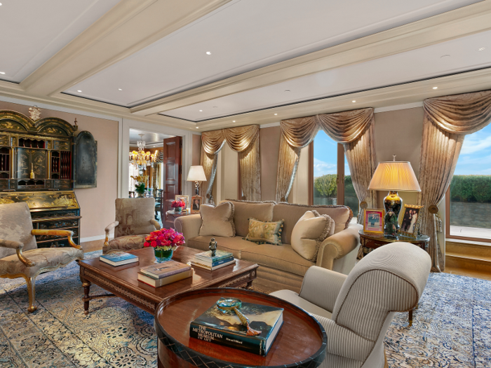 The living room features an antique marble fireplace and French doors that open up to an impressive terrace.