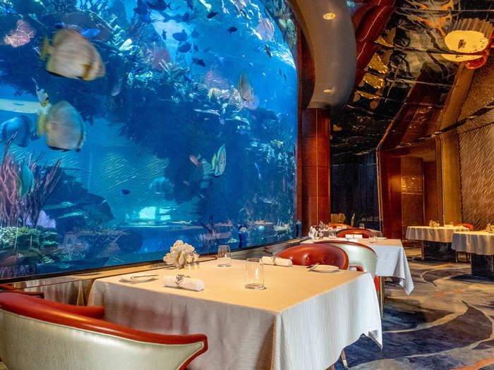 The dining room of Al Mahara wraps around a floor-to-ceiling 260,000-gallon aquarium filled with fish (not the ones you