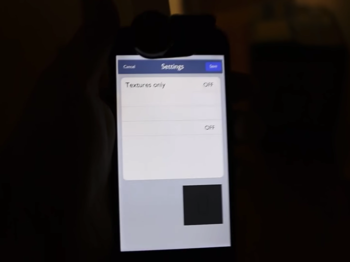 When Burrough walks into a dark room, or is covered by shadow, the device and the UI are also both in the shadow, which means there are no lighting effects on the phone. The UI elements, like the buttons up top and the shading on the square toward the bottom, completely disappear.