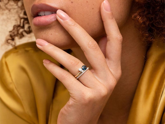 A simple round cut sapphire ring accompanied by a pair of diamonds