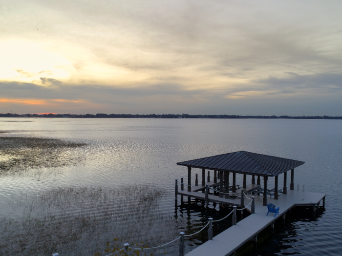 A private pier with two covered boat slips stretches out onto Lake Butler.