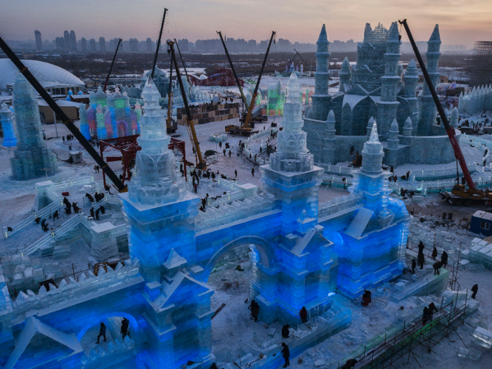 Other cranes help workers construct tall ice sculptures out of ice blocks.