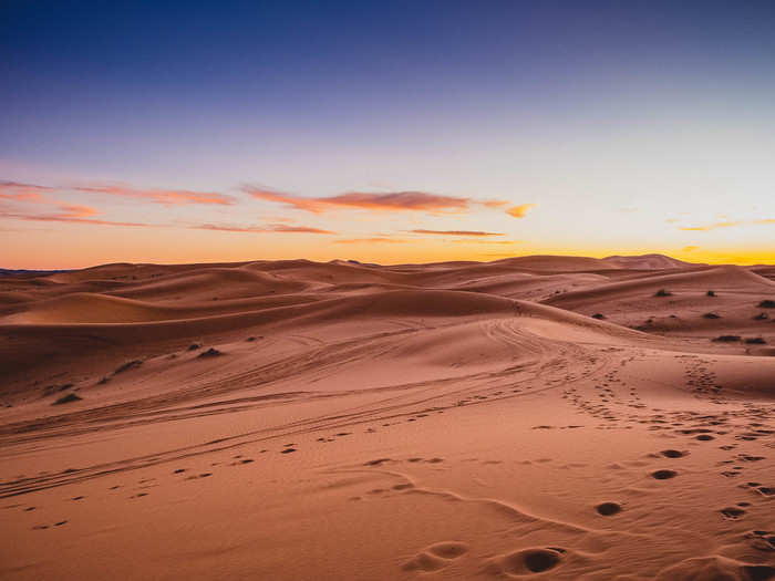 The sky was lit up in deep purples, oranges, and yellows, which were cast onto the dunes.