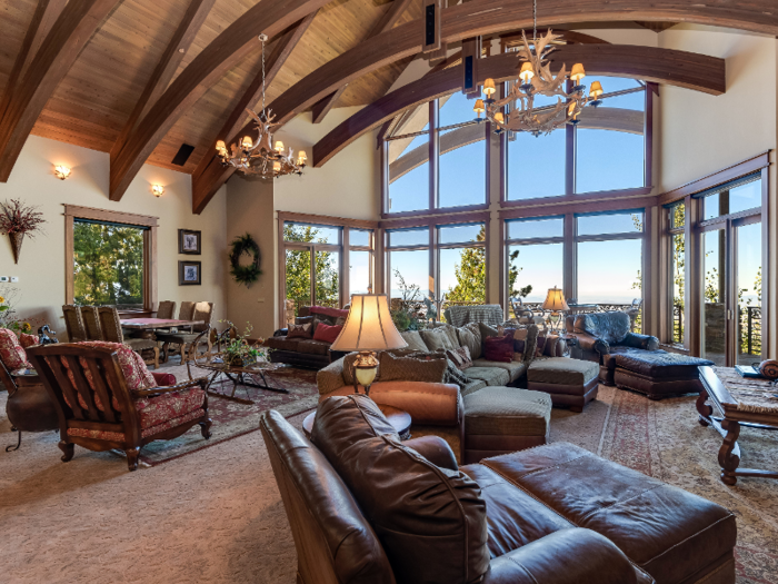 The great room features vaulted ceilings with tall windows, and plenty of comfortable places to sit.