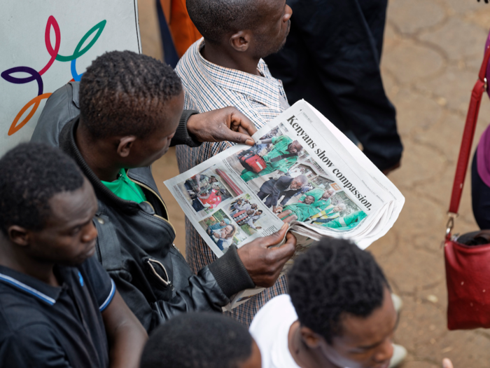 DusitD2 said on its website: "We are extremely saddened by this act of violence." Here, a man reads a newspaper article about the attack near the scene of the siege on Wednesday.