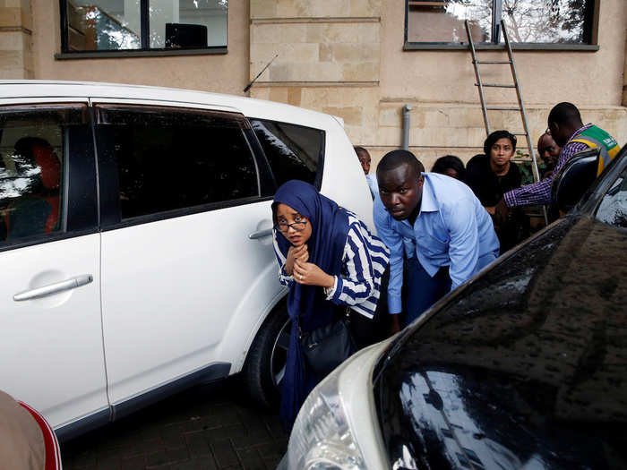 These civilians hid behind a car.