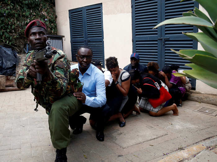 Elsewhere in the complex, civilians also hid in a line behind a member of the Kenyan security forces.