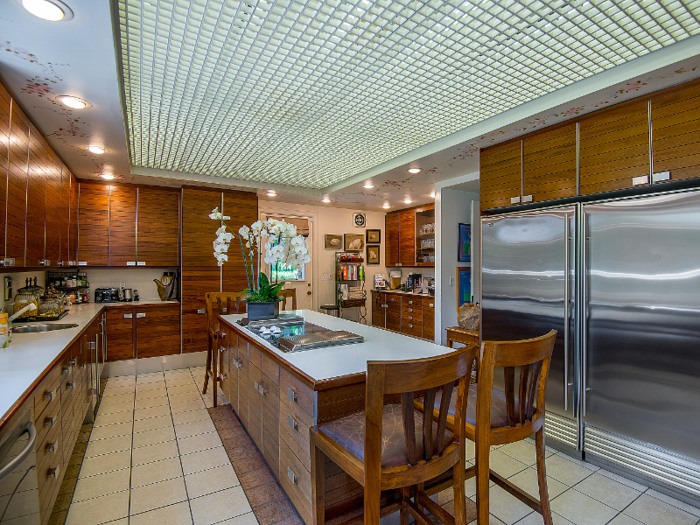 The kitchen features ample counter space and what appears to be a massive refrigerator.