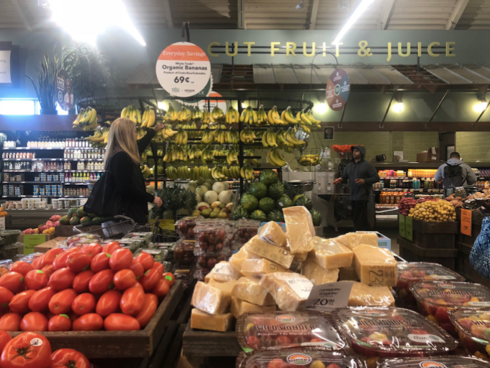 Behind a giant shelf of bananas, there is a counter with fresh-squeezed juice.