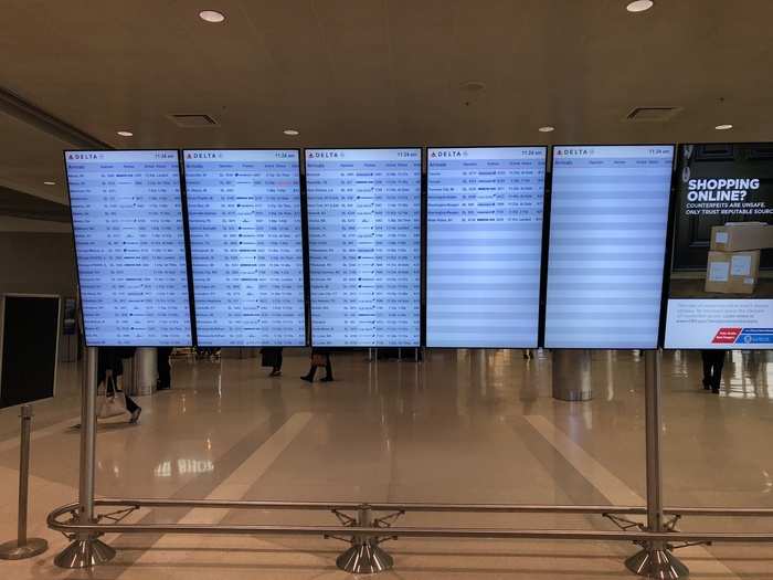 Electronic signage showing arriving and departing flights is abundant.