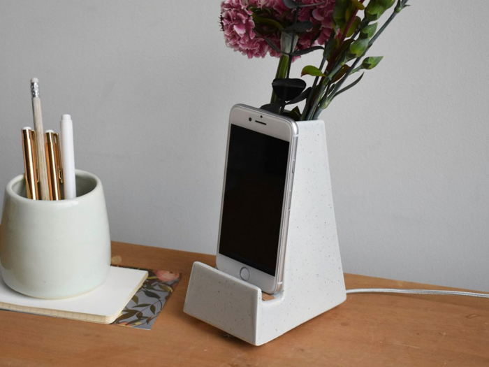 A clay vase and phone stand that adds a nice touch to their desk