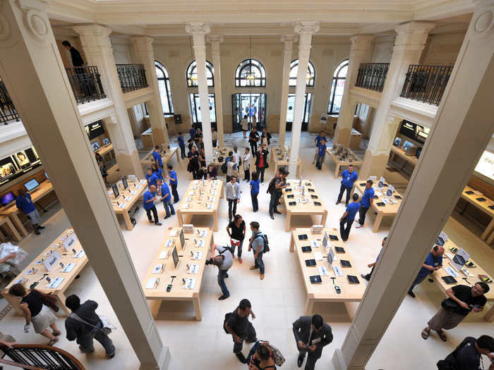 Inside, you will find a typical looking Apple store, but with a historic feel. White pillars stand strikingly tall, and black balcony railings cut through the space. Light shines down through a large-scale skylight.