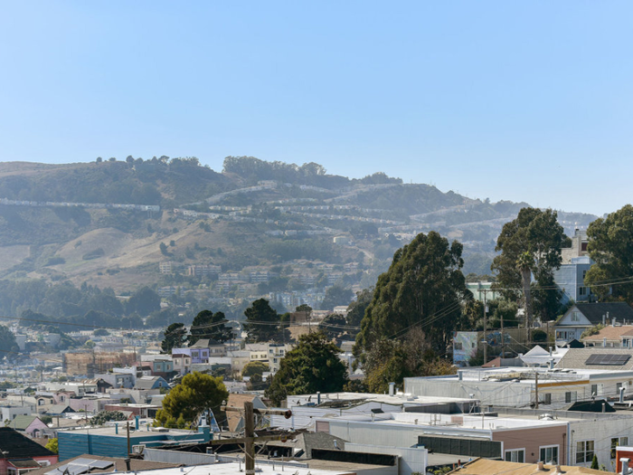 You can see over the rooftops of houses to the rolling hills in the area.