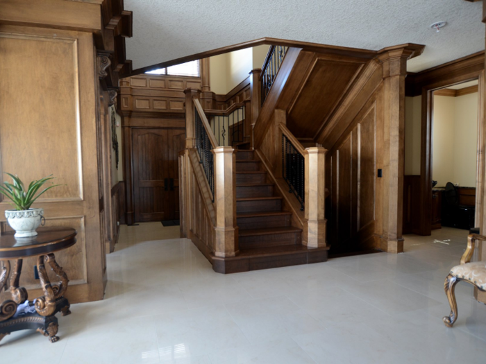 ... into the spacious foyer, which is complete with a large wooden staircase.