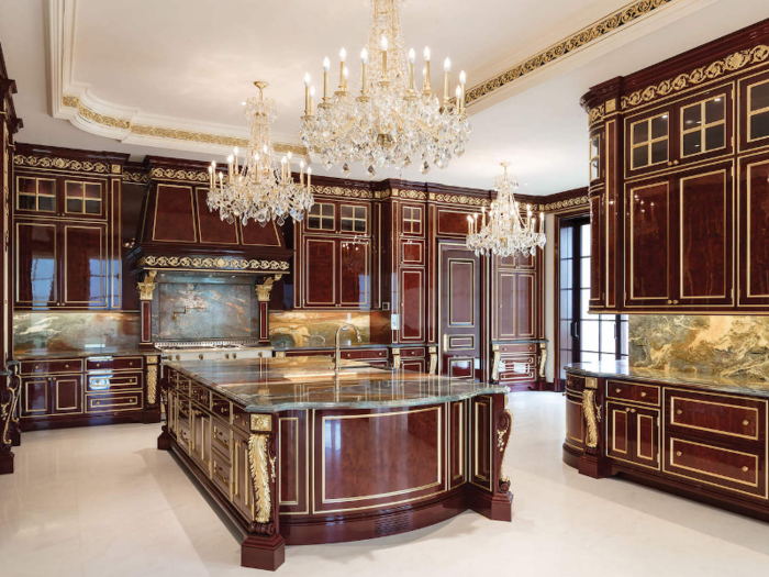 The lavish kitchen is made with mahogany wood and accented with gold leaf gilding.