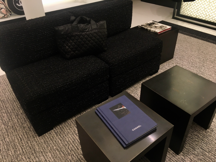 A plush black couch had a Chanel bag propped on it, along with a Cruise Collection look book ...