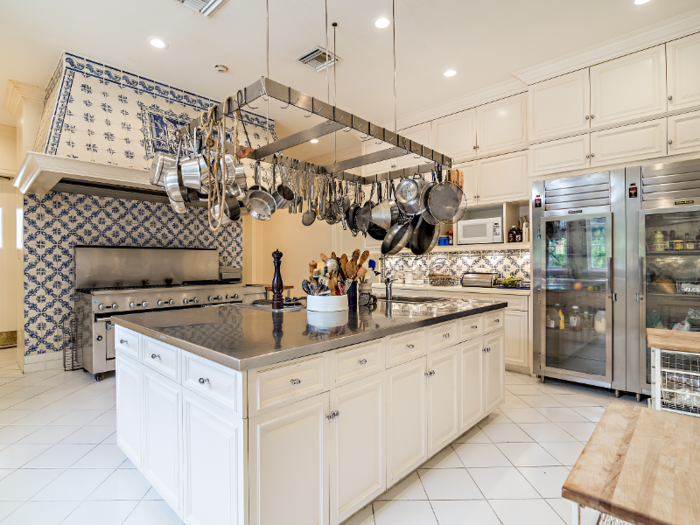 The kitchen features white cabinets and stainless steel appliances including a large gas range.