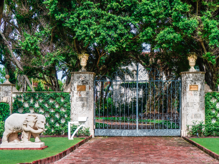 The entrance to the estate, called "La Follia," is marked by an opulent wrought-iron gate and a pair of elephant sculptures.