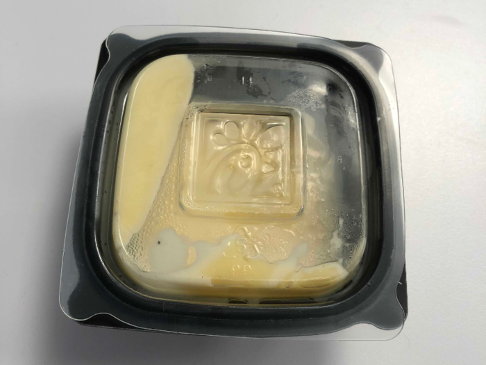 In reality, the sauce comes in a plastic container, not a paper one. But it is that white color, which is a good sign, as I think yellow in cheeses usually indicates it