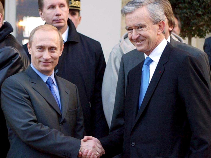 Here, Arnault can be seen shaking hands with Vladimir Putin during the Russian president