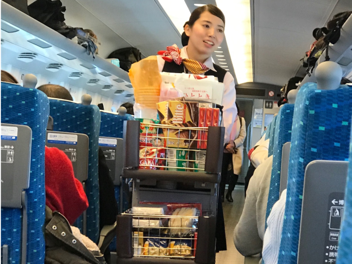 A lady with a cart passed by several times. She sold beverages, snacks, and cups of noodles.