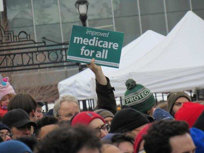 As Sanders spoke, people in the crowd held up posters that emphasized their support for him and the issues he