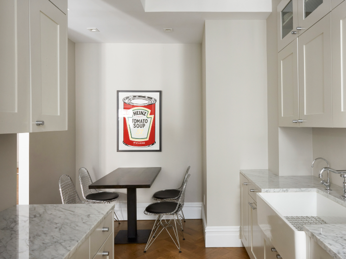 Now, the eat-in kitchen is unrecognizable, painted completely white with fresh marble countertops. New cabinets and hardware were also installed, further adding to the apartment