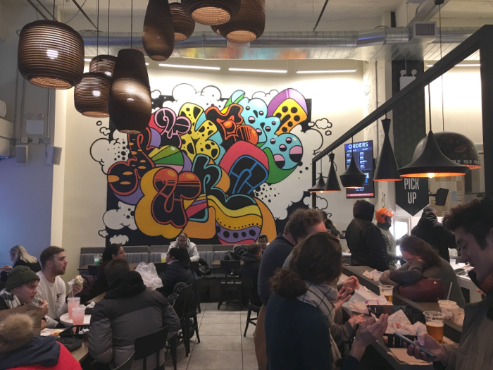 Inside, the cozy space was buzzing with customers. Hanging lamps of various shapes and sizes, plus a colorful graffiti mural, added a casual, yet playful, feel to the space.