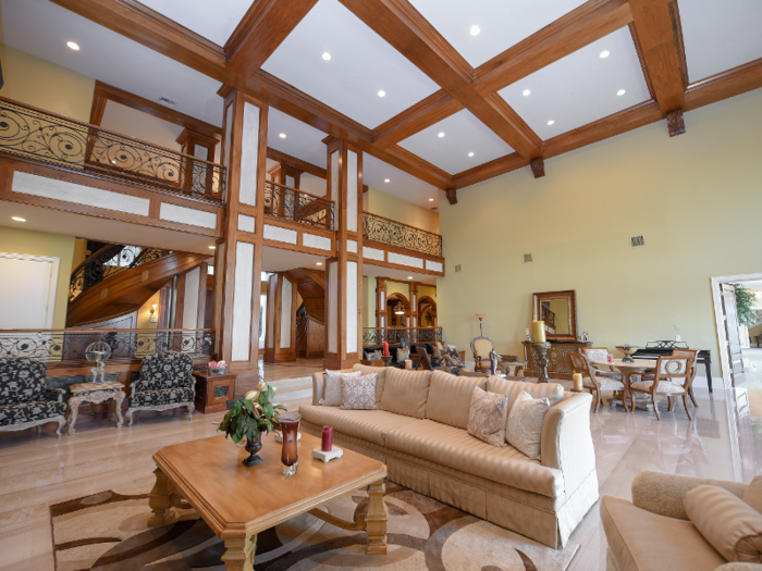 The entryway features a curved double grand staircase and polished marble floors, leading into the 1,170-square-foot great room.