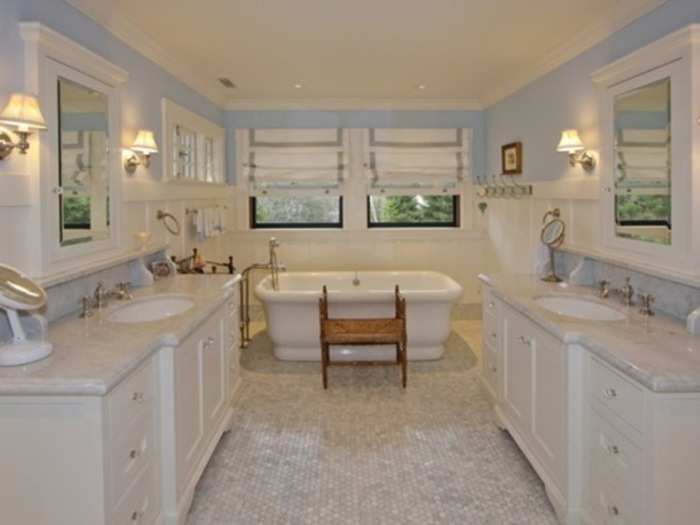 ... a bathroom with a tub centerpiece and his and hers sinks ...