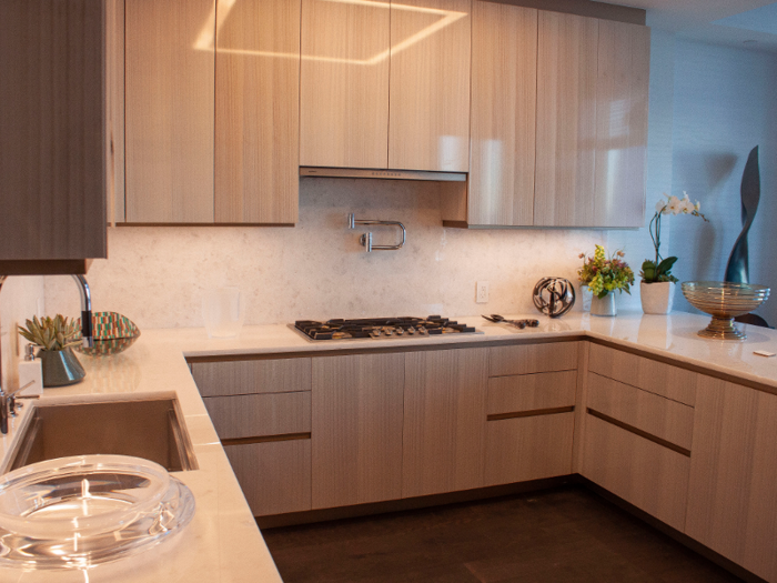 In the kitchen, cabinets are made of eucalyptus and the counters are opal white marble.