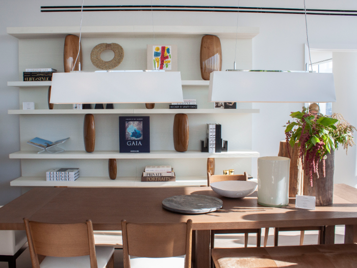 Built-in shelving lines the wall behind the dining table.