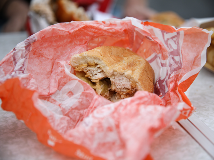 The sandwich comes dressed in lettuce, pickles, and mayo with two chicken tenders tucked in a French baguette.