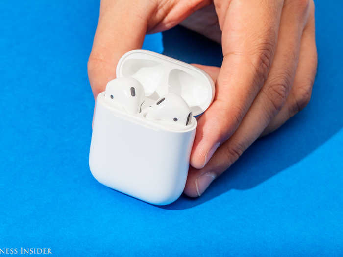 2. Hold down the button on the back of the AirPods case and open the lid.