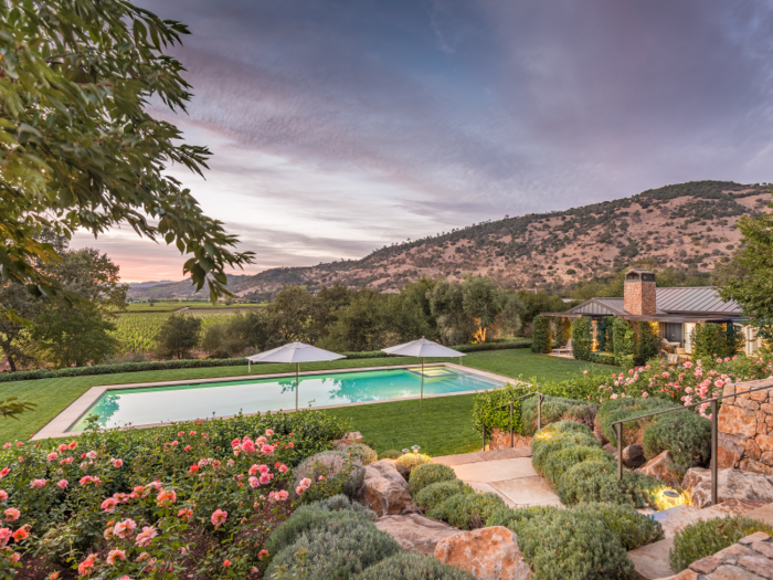 The manicured grounds include a rose and dahlia garden. By the pool is a one-bedroom guest house with a full kitchen, bathroom, and living room.