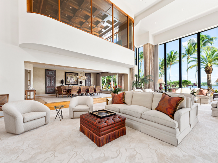 ... while the living room is finished with carpeting and features floor-to-ceiling windows.