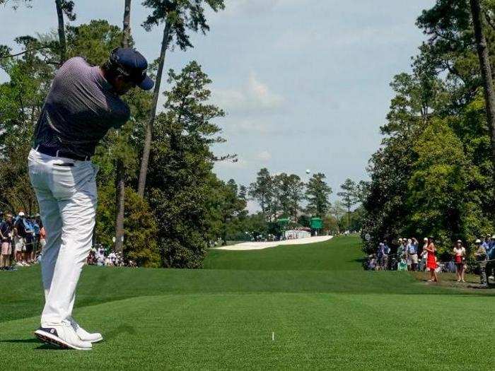 Corey Conners hits a ball down the fairway.