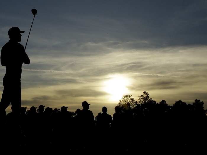 Brooks Koepka and the patrons watch the flight of the ball.