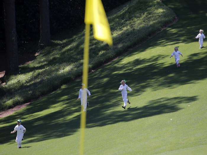 Several children run down a hill during the par 3 contest.