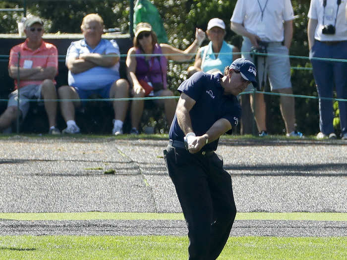 Phil Mickelson skips a ball across the water during a practice round.