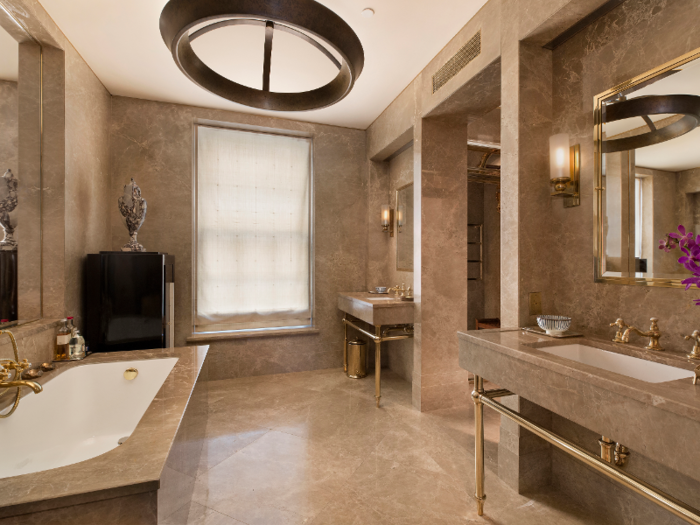 The marble master bathroom features double vanities and a soaking tub.