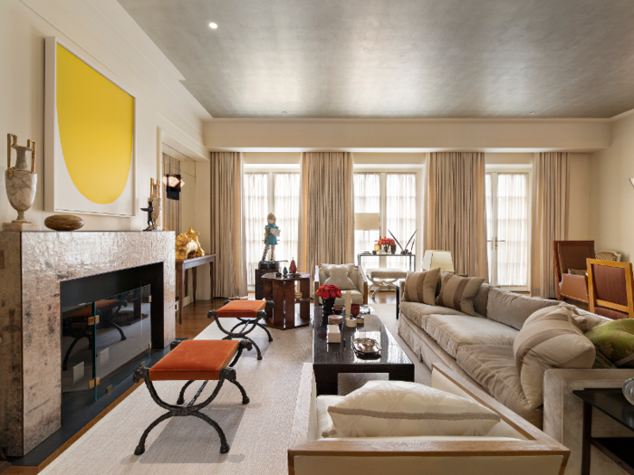 The living room features tall windows and a fireplace.