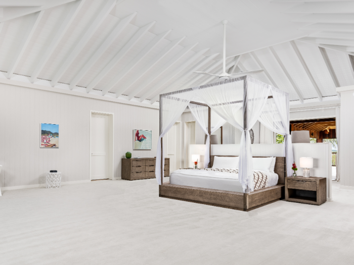 The all-white master suite — complete with a canopy-covered bed under a lofted ceiling — takes up the entire second floor of the main house.